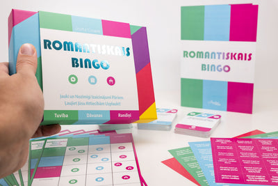 romantiskais bingo, tur rokās, balts fons, aizmugurē redzamas kārtis, instrukcija un uzlīmes